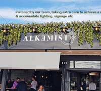 UV-treated artificial greenery softens Cafe facade & frames signage...